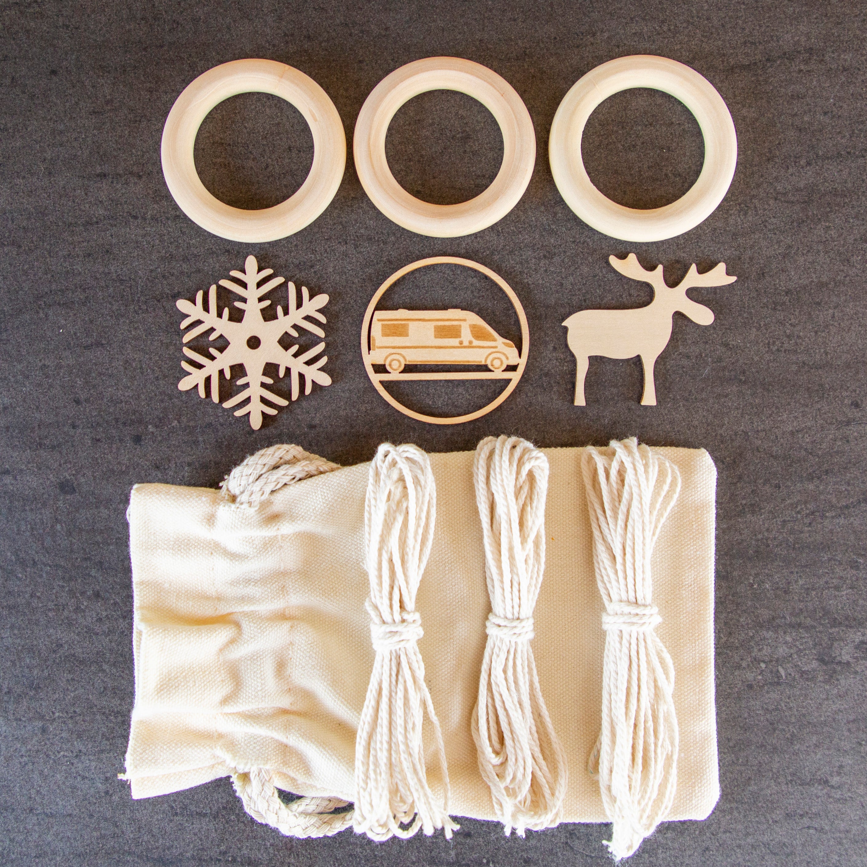 Bestandteile DIY Set Weihnachtsanhänger Camping mit Holzringen, Garn, Baumwollsäckchen und den drei Motiven Flocke, Elch & Kastenwagen